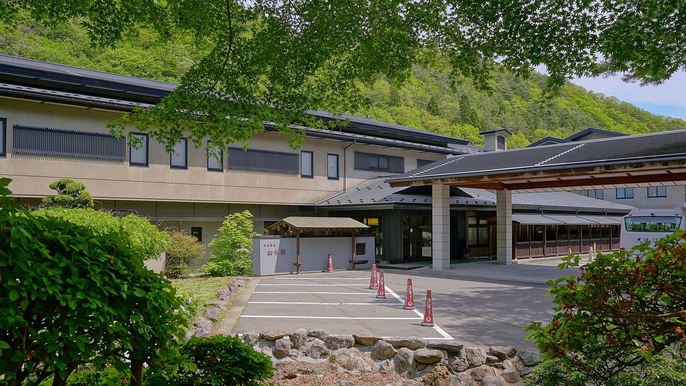The landscaped entrance and modern buildings of Sansuikaku at Osawa Onsen.