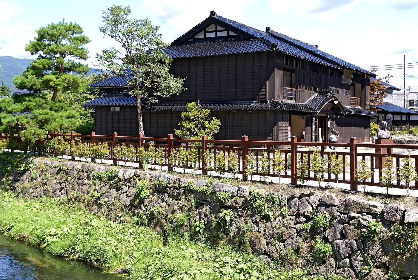 The traditional former-storehouse building and stream at Tono’s storytelling museum.